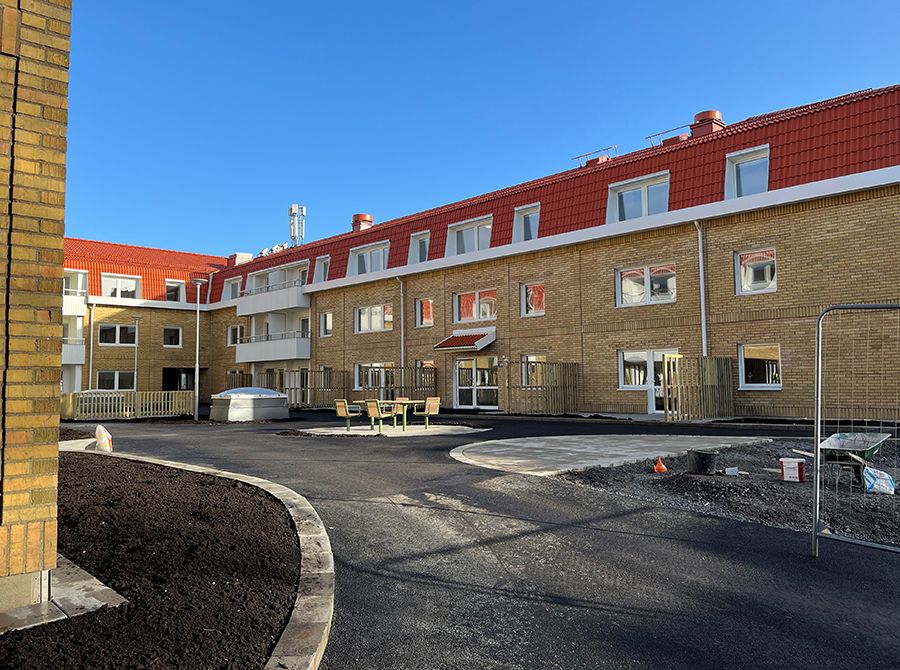 Tre våningar hög gul tegelbyggnad med rött tak.