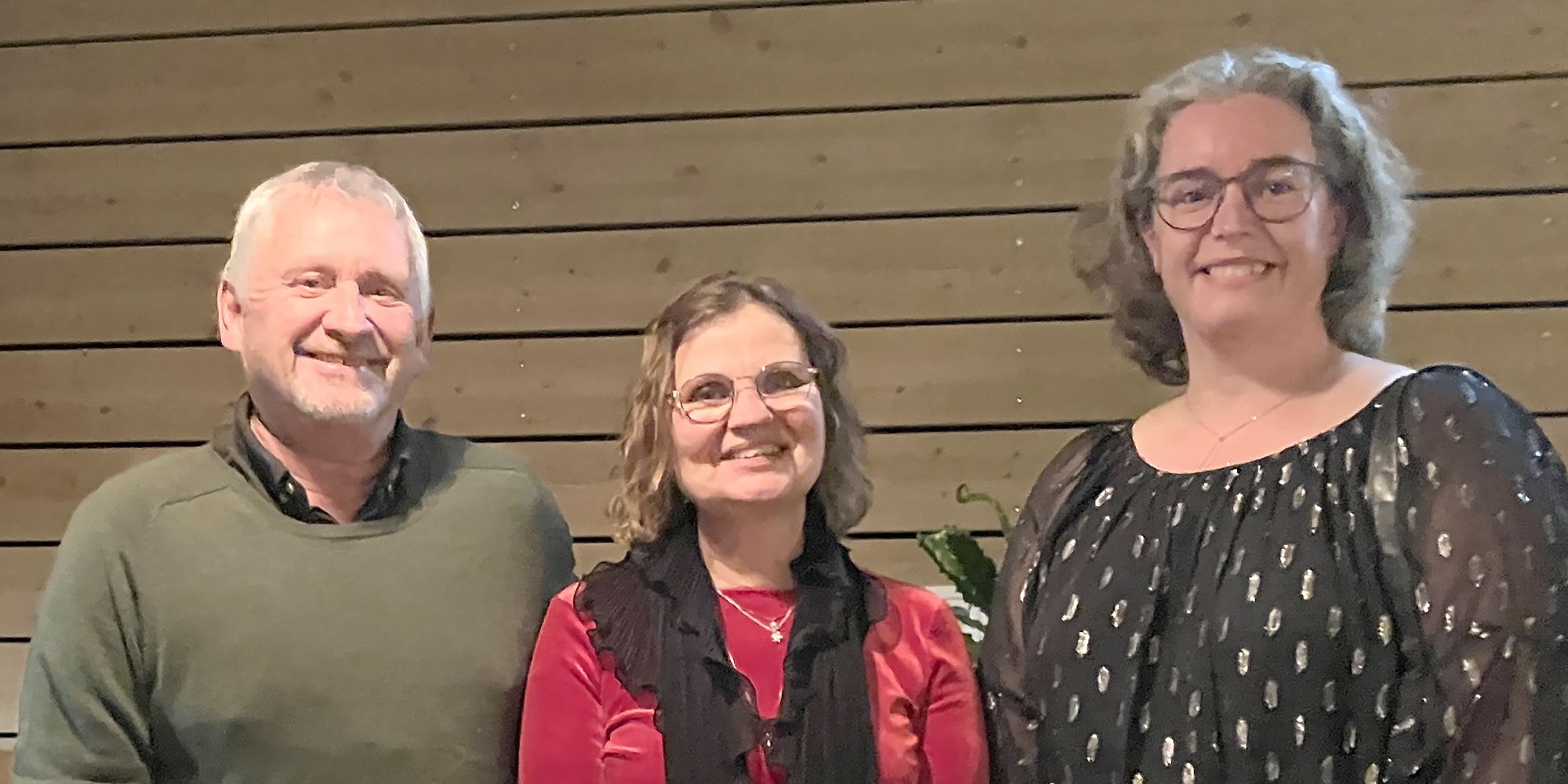 Niels Töttrup, Kicki Nordberg och Annelie Gustafsson står inne framför en vägg. De är festklädda och ler.