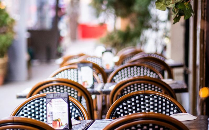 Bord och stolar utomhus, med grönska runt om.