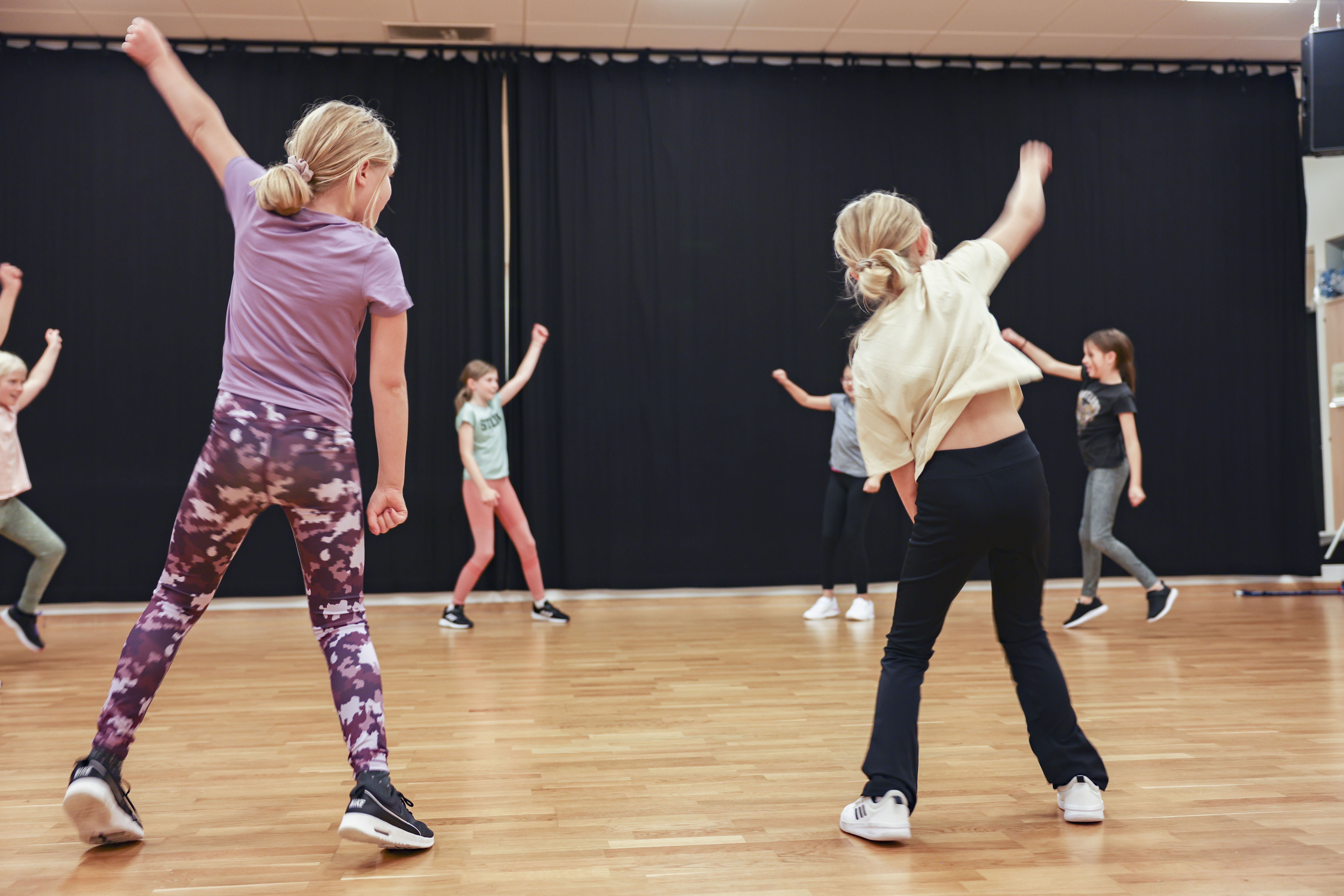 Barn i färgglada kläder dansar