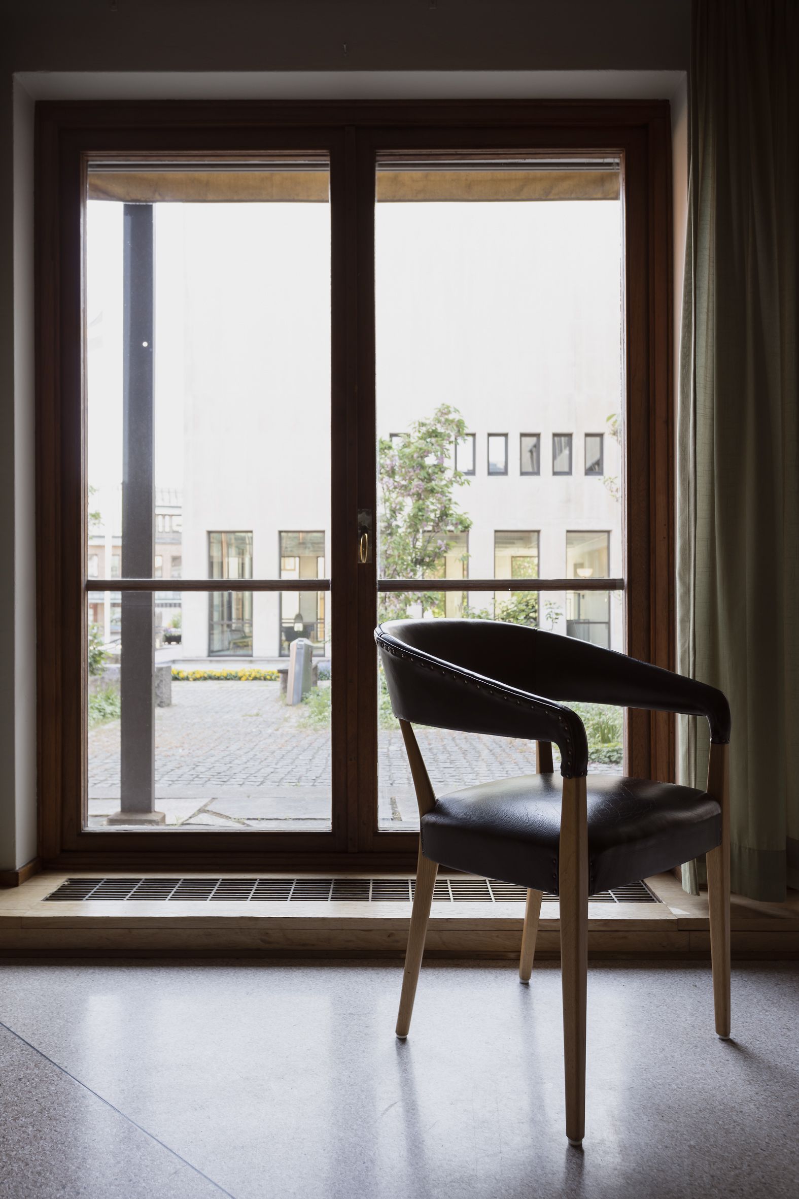 En stol vid ett fönster. Utsikt mot Rådhuset.