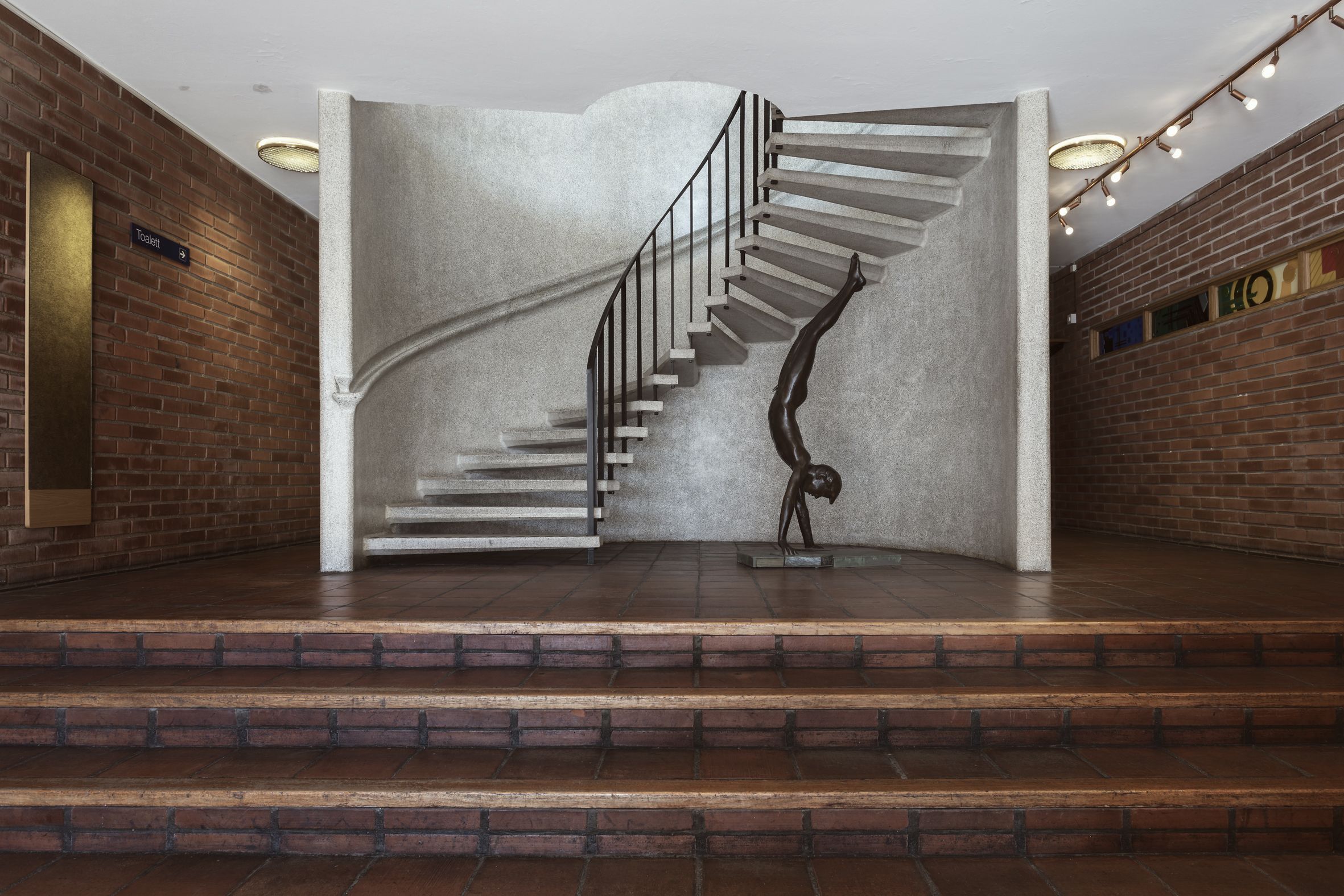 En trapp. Bredvid trappen är en staty av ett barn som står på händer.