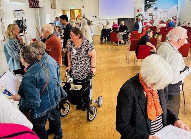 Människor går runt och tittar i en stor sal.