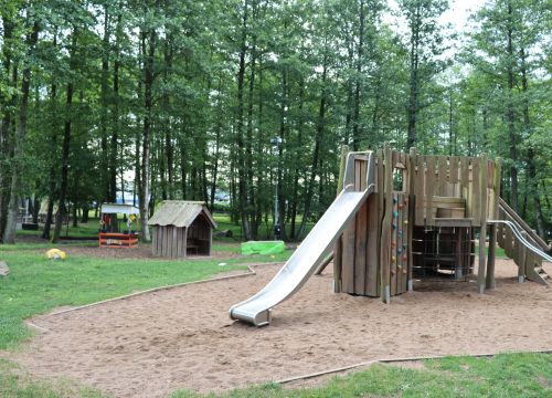 Klätterställning med rutschkana med skog i bakgrunden
