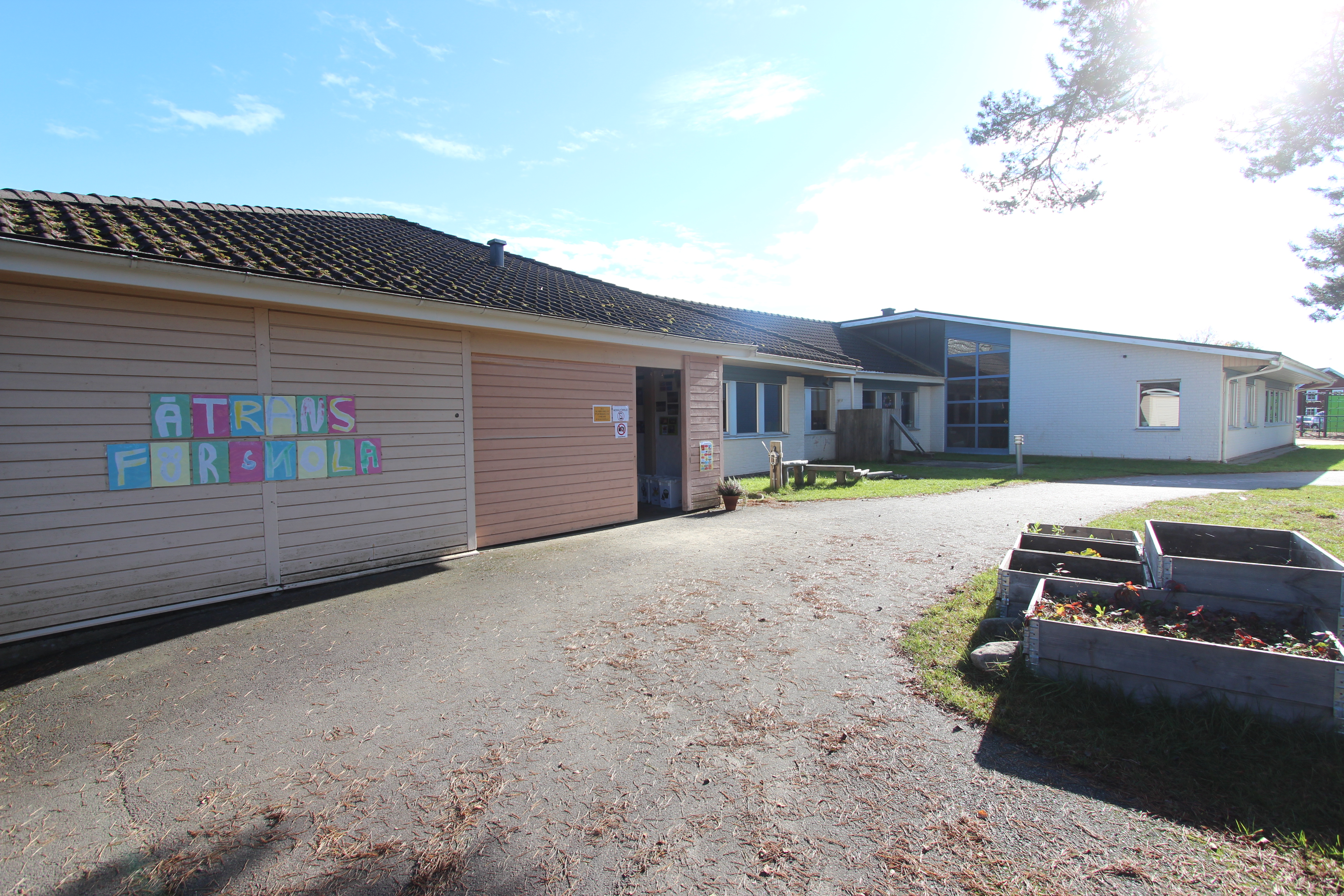 Låg byggnad i rosa och vitt med "Ätrans förskola" på fasadväggen