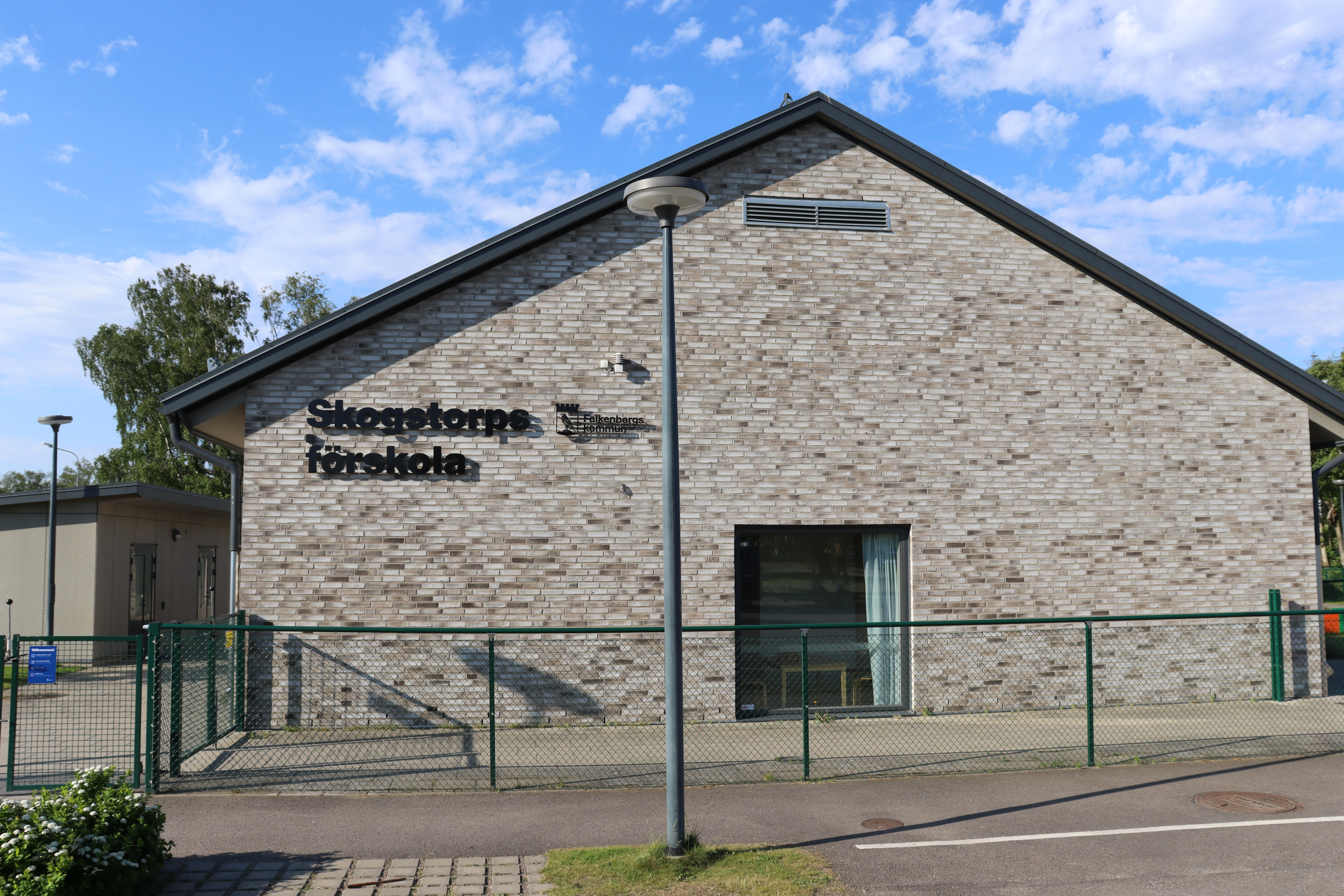 Röd tegelbyggnad sedd från gaveln med skylten "Werners Hages Förskola"