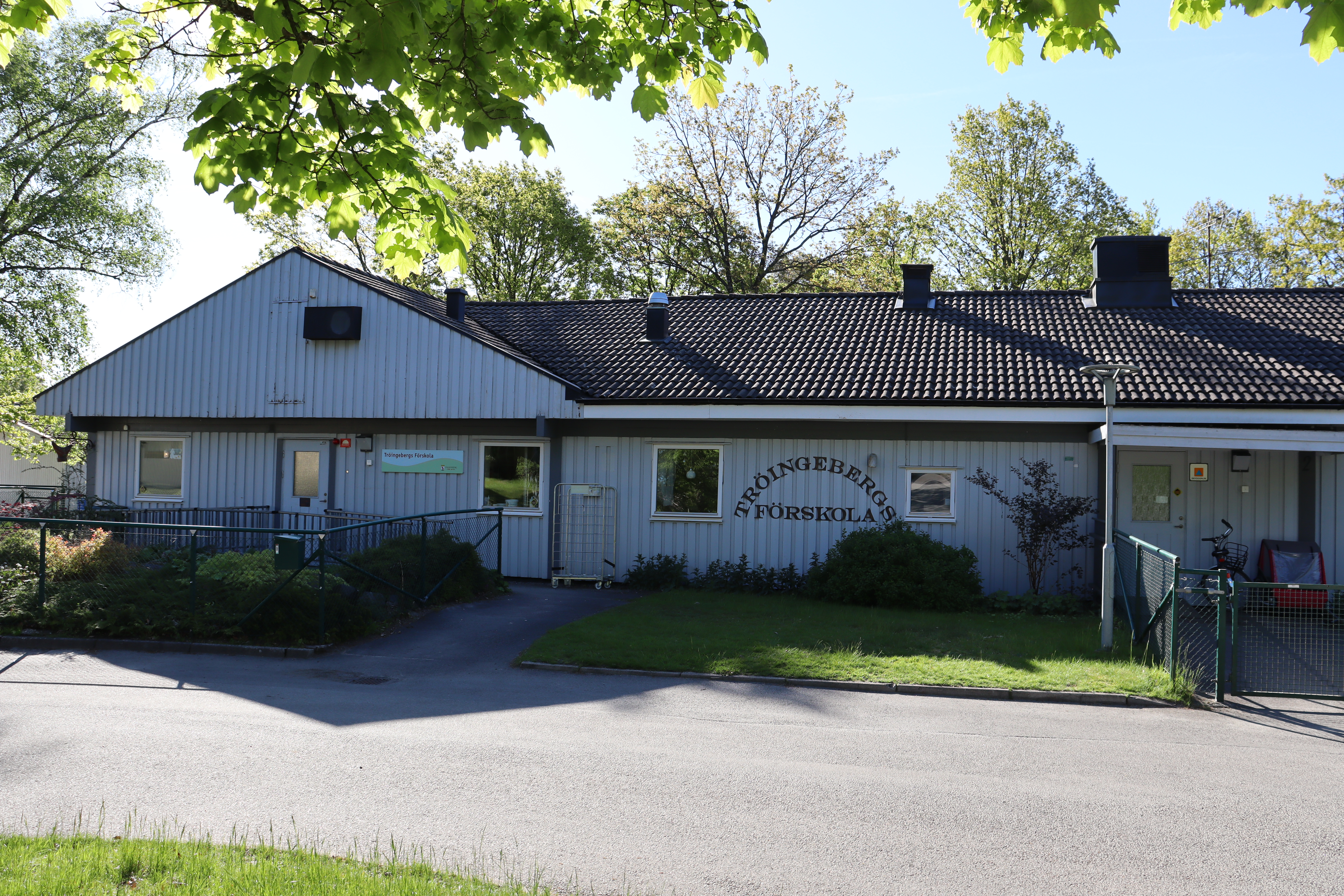 Låg vit byggnad sedd från långsidan, Tröingebergs förskola på fasadvägg