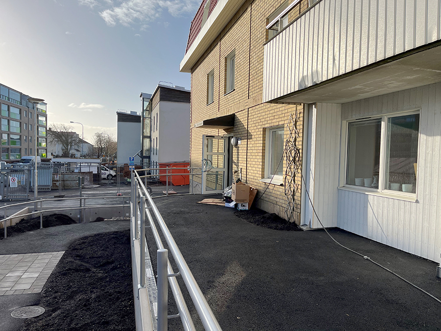 Gul tegelbyggnad med räcke framför.
