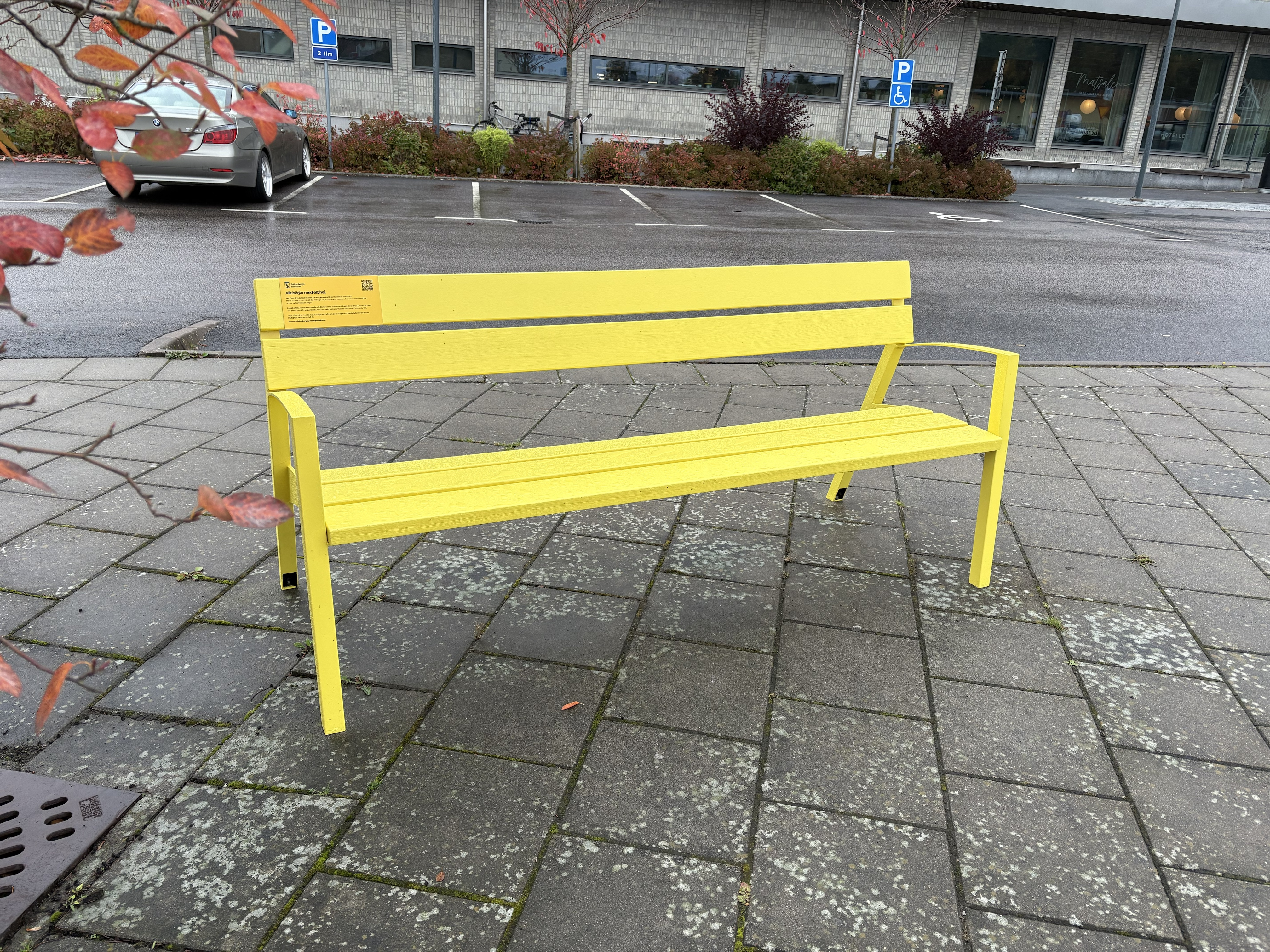 En gul bänk i trä vid busstationen i Ullared.