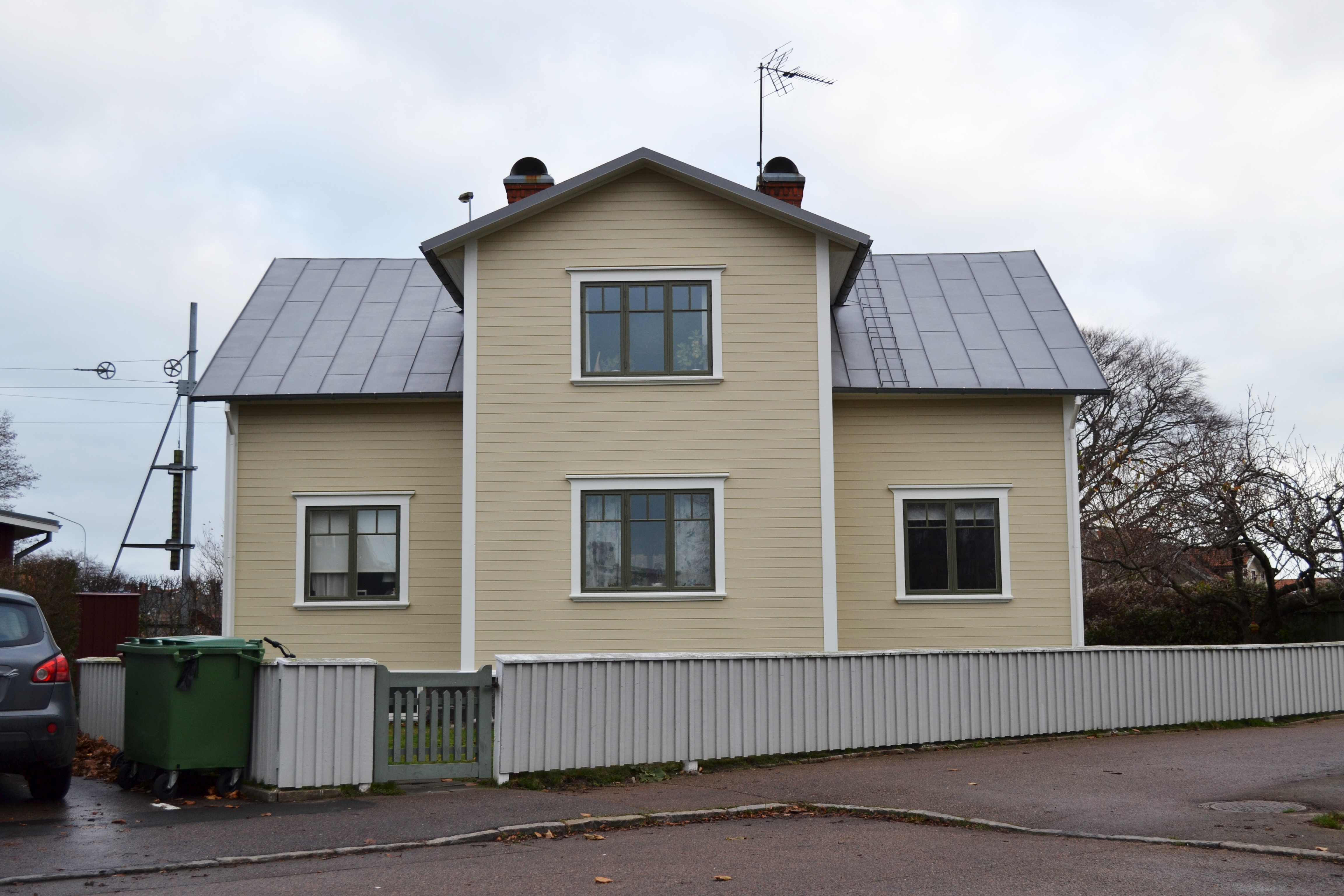 Ett ljusgult hus med svart tak.