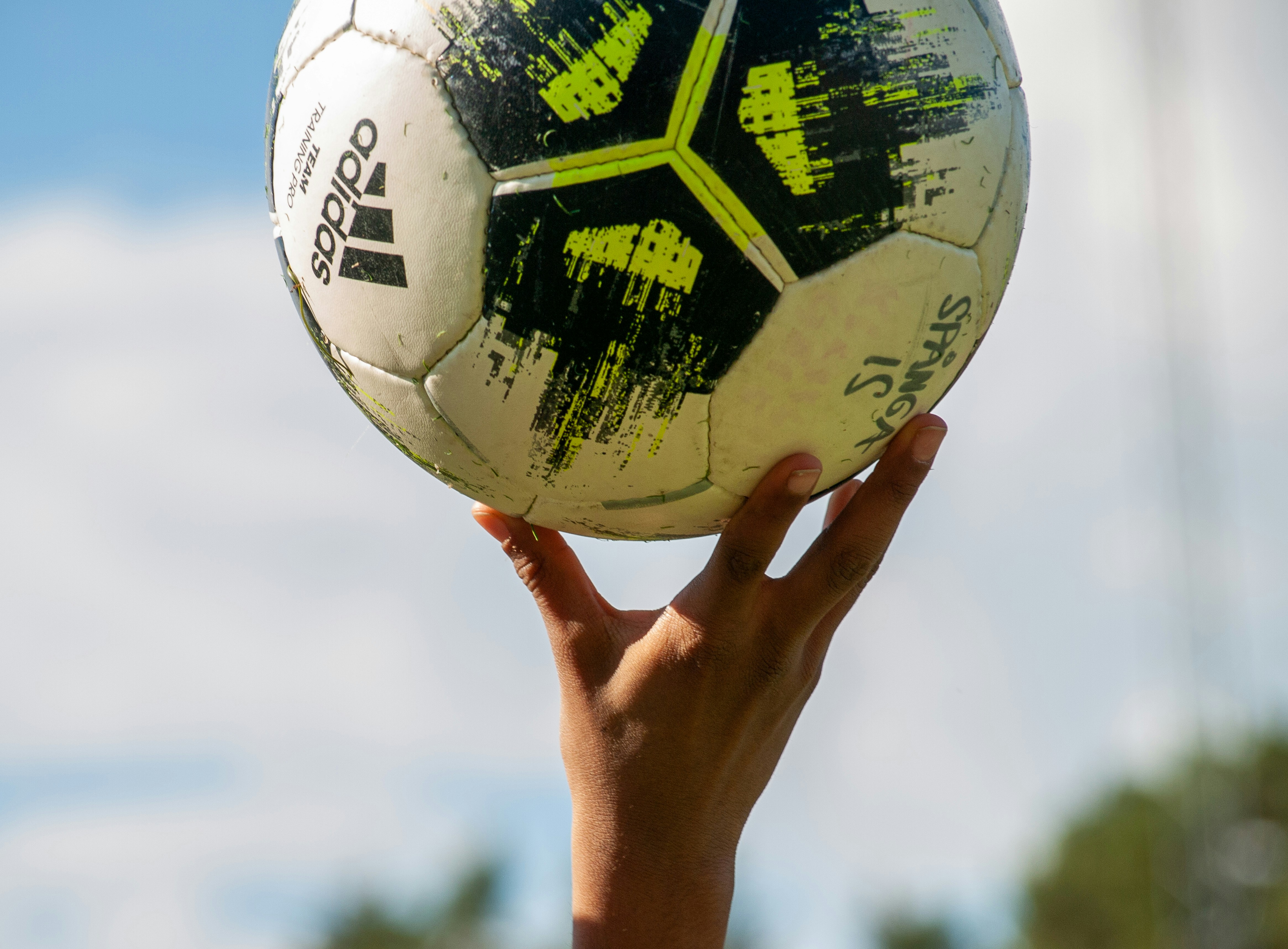 Bild på barns hand som lyfter upp en fotboll.