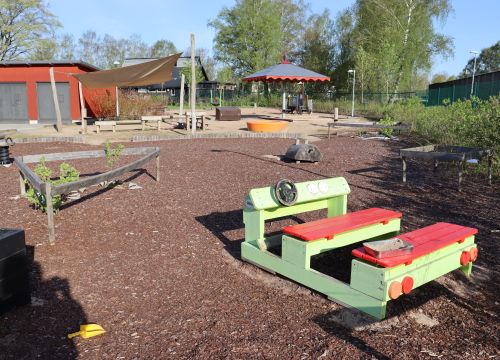 Grön och röd träbil, gården i bakgrunden