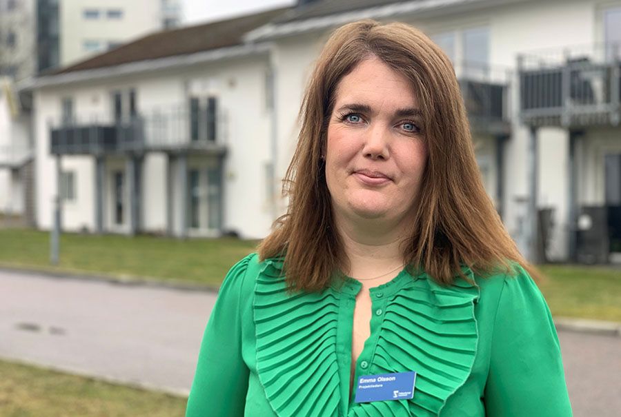 Brunhårig kvinna i smaragdgrön blus.