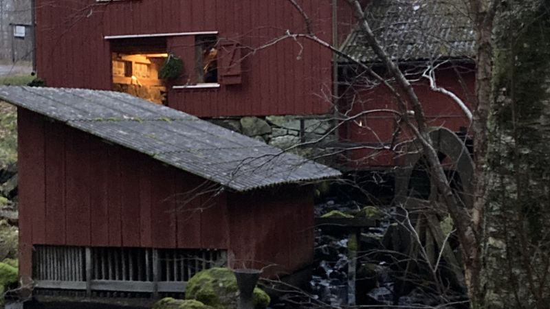 Röd kvarn vid en fors en höstdag. 