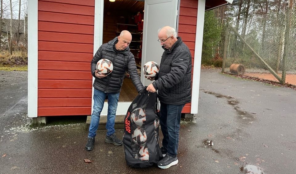 Dag, Tommy och en säck bollar utanför ett rött förråd med vita knutar.