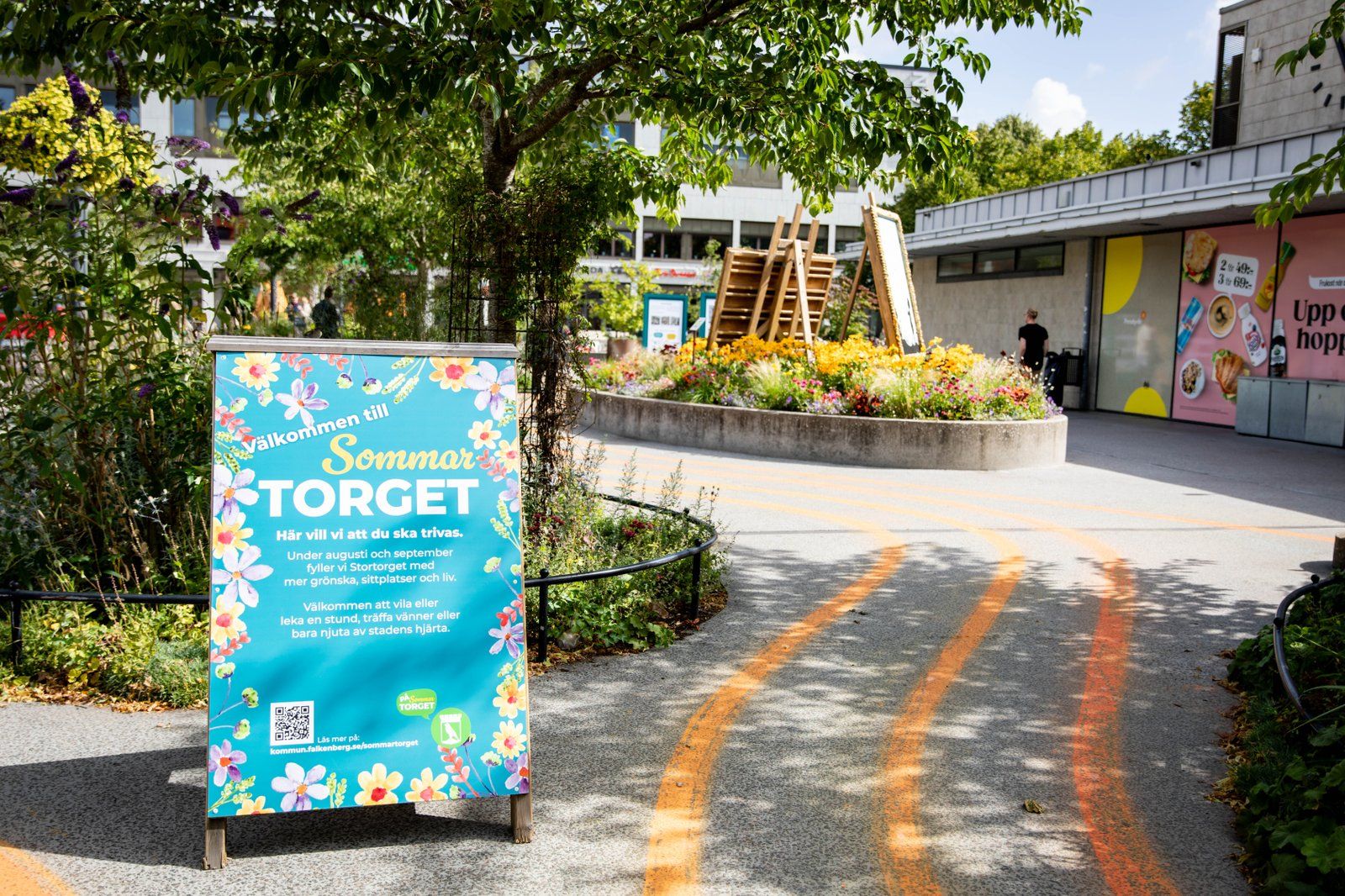 Trottoarpratare i förgrund som välkomnar till sommartorget 2025.