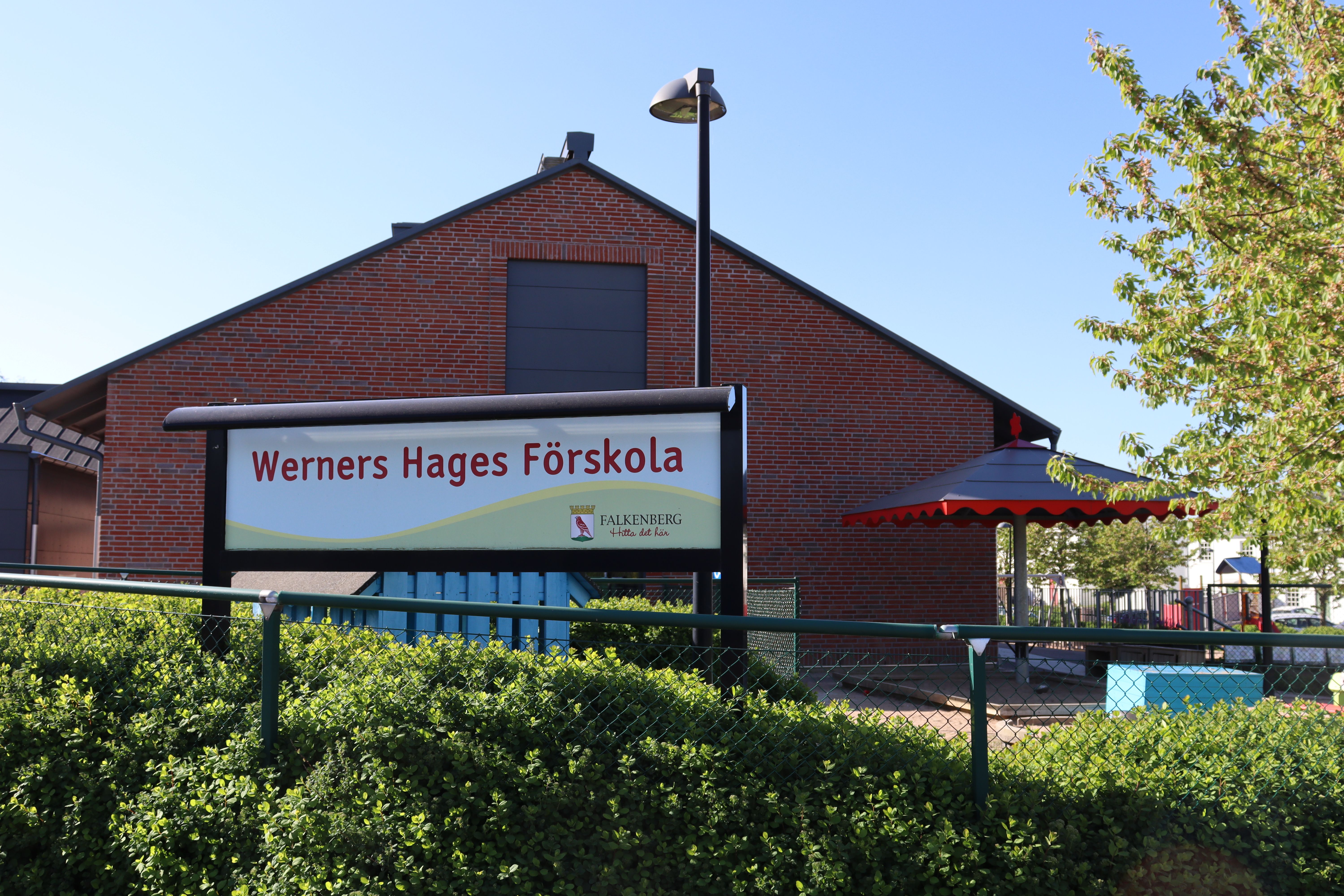 Röd tegelbyggnad sedd från gaveln med skylten "Werners Hages Förskola"