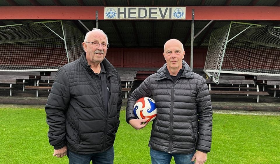 Tommy och Dag på planen framför läktaren med texten Hedevi. På läktaren är målen inknölade för vintern.