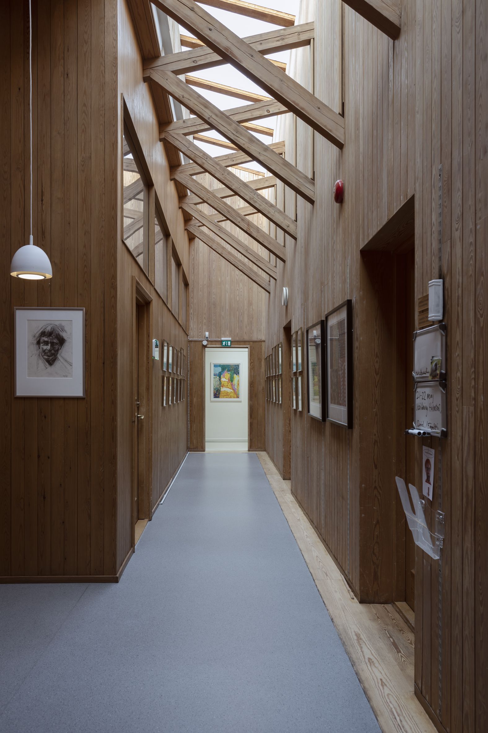Interiörbild från en korridor med bjälkar och takfönster.