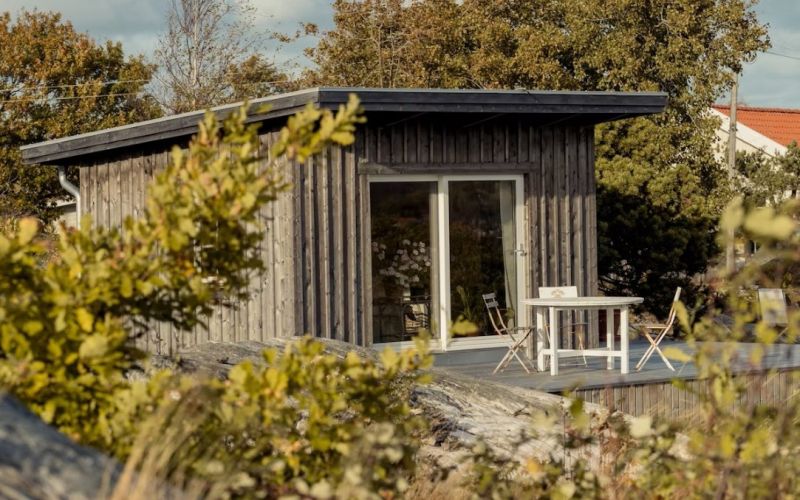 Liten byggnad i trä med stora fönster.